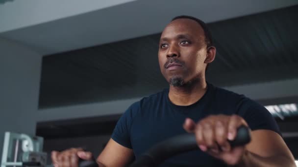 Μαύρος Άνθρωπος Κάνει Καρδιο Προπόνηση Κάθεται Μηχανή Ποδήλατο Crossfit Γυμναστήριο — Αρχείο Βίντεο