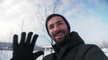 Genç adam kameraya bakarak görüntülü arama yapıyor. Kar doğası arka planı. Konuşan blogcu kafa iletişimi kayıt videosu. Pov Guy akıllı telefondan selfie çekiyor. Yüksek kalite 4k görüntü