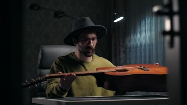 Człowiek Patrząc Gitarę Domu Młody Facet Nosić Gitarę Kapelusz Siedzi — Wideo stockowe