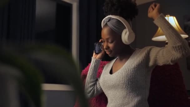 Zwarte Vrouw Luisteren Muziek Dansen Zitten Stoel Huis Interieur Afro — Stockvideo