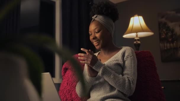 黑人妇女坐在黑暗的房间里 用笔记本电脑庆祝胜利 惊讶地看着电脑 在家里拍手 高质量的4K镜头 — 图库视频影像
