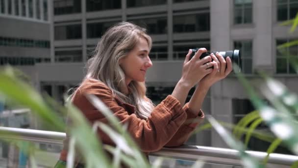 Молодая Блондинка Фотографирует Современные Городские Здания Фотограф Леди Использует Фотоаппарат — стоковое видео