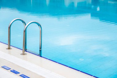 Yüzme havuzunda merdiven ve mavi su fotokopi alanına yakın çekim