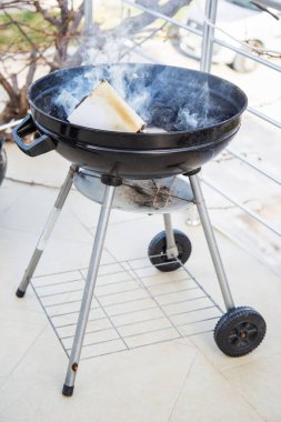 Bahçedeki terasta kömür ve odunla ızgara.