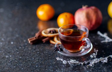 Tarçınlı çay, arkaplanda nar ve mandalina, baharatlı sıcak kış çayı ve narenciye.