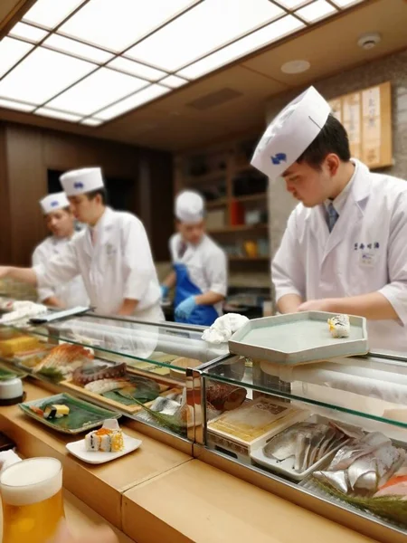 Tezgahta beyaz üniformalı Japon şefler.
