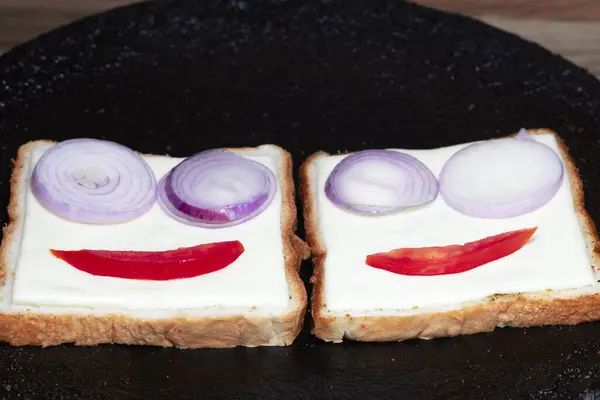 Siyah bir tavada soğan ve domates satan bir yerde gülen kavram.