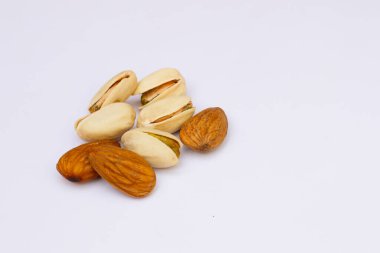 Beyaz arka planda 3 badem ve 5 fıstık var.