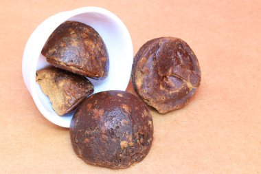 Güney Hintli, Tamil Nadu... Kahverengi arka plana yerleştirilmiş beyaz kasedeki ünlü palmiye parçacıkları.