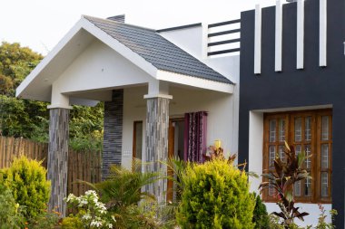 Gri desenli ve bahçeli beyaz renkli çiftlik evi.