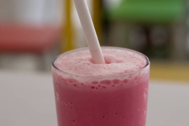 Beyaz bardakta servis edilen renkli ve lezzetli gül sütü. 