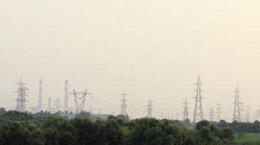 Yüksek voltajlı elektrik kuleleri yeşil manzarayla birlikte sanayi bölgesini çevreledi.