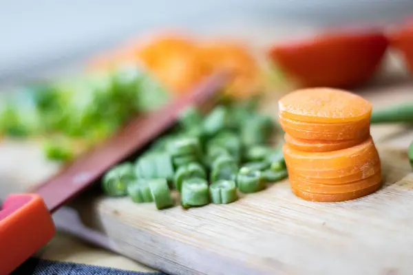 Önlüklü mutfak masası, tahta kesim tahtası, kırmızı Alman bıçağı.