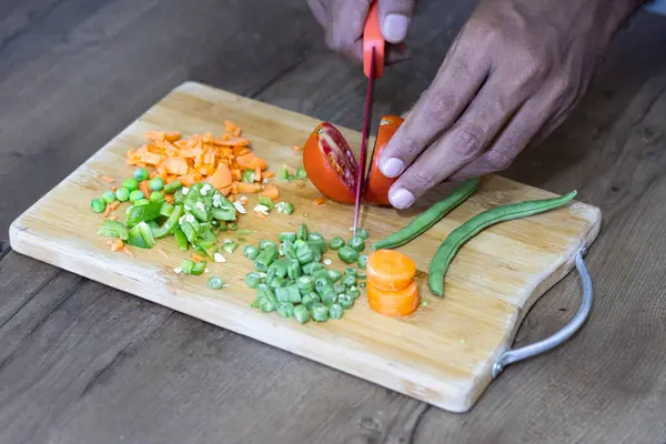 Mutfak masasında, adam totomatı 2 armut olarak kesiyor.