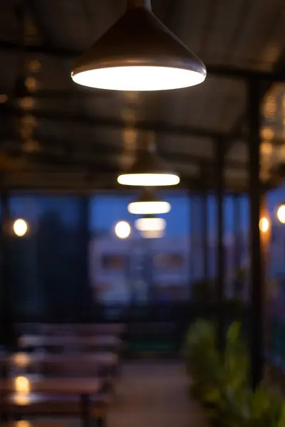 White light hanging above the sidewalk way in the open restauran