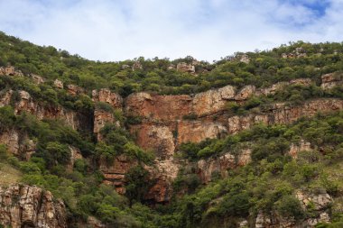 Kailasa Kona Şelalesi 'nde, yeşil renkli dev kahverengi kayalar. 