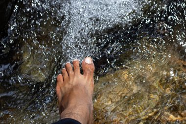 Erkekler Moola Kona Waterfa 'nın akan sularında yalınayak dolaşırdı.