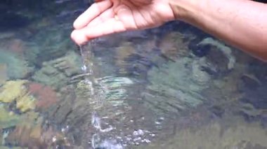 İnsan eli suyu yakalayıp temiz suya geri döker.