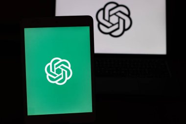 Masada yeşil arkaplan ve dizüstü bilgisayarlı Chatgpt logosu var.