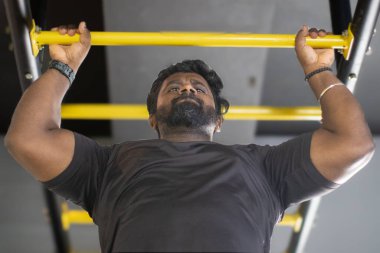 Sarı ızgara merdiveni tırmanan adam ağırlığı azaltmak için...