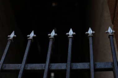 Üzerinde gri çiviler olan siyah bir çit.