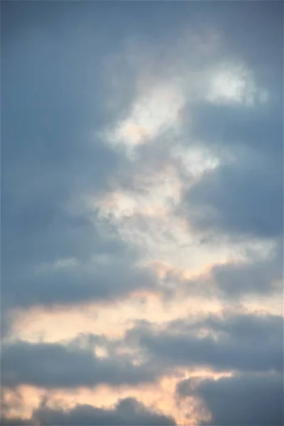 Lines of sun rays in blue clouds, sun behind cloudy clouds