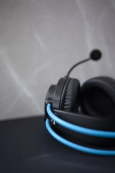 Black headphones with blue tubes that go around the head, headphones with a microphone