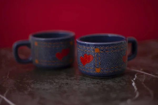 Two blue coffee mugs with red hearts on them, a small sign of attention to a loved one, a gift for a loved one