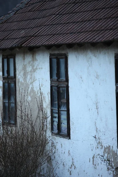 白いファサードと赤いタイルと老朽化した古い家の古い木造窓 — ストック写真