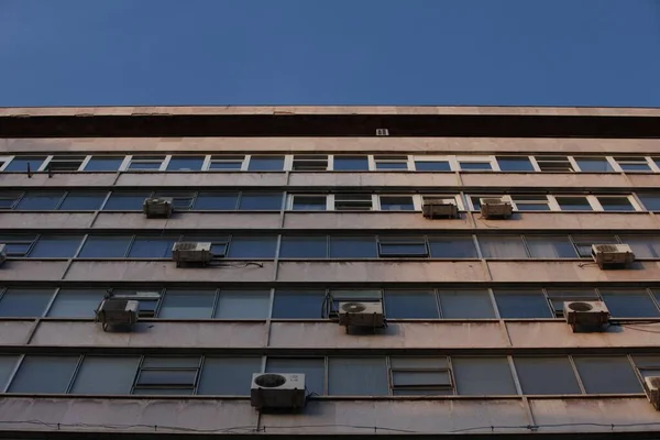 Big building with windows in line, bottom view, blue sky