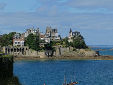 Dinard, Fransa - Ağustos 2018: Breton kıyısında Dinard sahilinde yürümek. Güzel ve büyük turistik evlerin ve eski tahkimatların genel görünümü