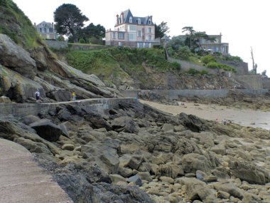 Dinard, Fransa - Ağustos 2018: Breton kıyısında Dinard sahilinde yürümek. Güzel ve büyük turistik evlerin ve eski tahkimatların genel görünümü