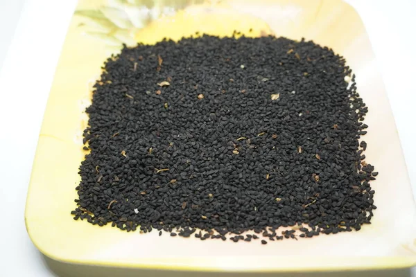 Siyah susam tohumları beyaz arka planda bir kasede