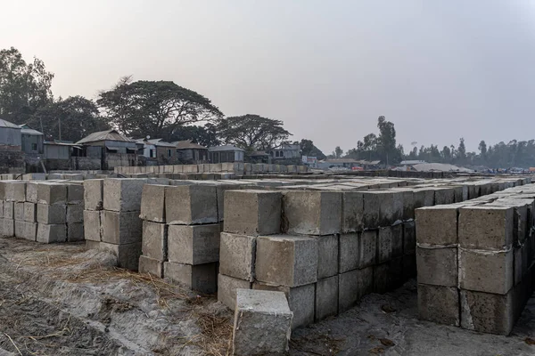 Üst üste dört kare tuğla yığını. Kaya kadar cesur. Blok arkaplanı üzerine beton küp.