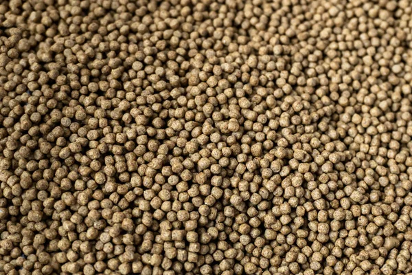 Fishery feed for fish feed. Fish feed pellets, close up of granulated fish food textur
