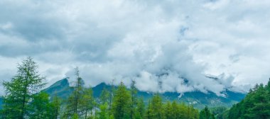 Alplerdeki dolomite dağları bulutlu ve manzara sisli.
