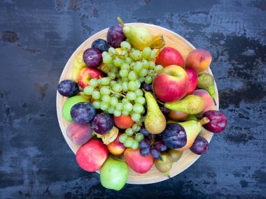 Masanın üstünde karışık meyveler. Üzüm, elma, armut.