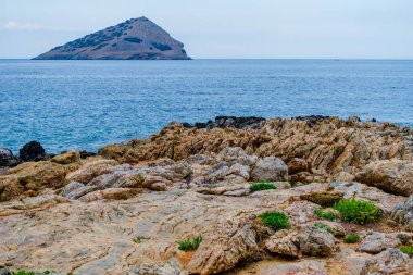 Kıyı açıklarında mavi deniz, kaya oluşumları, Yunanistan