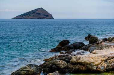 Kıyı açıklarında mavi deniz, kaya oluşumları, Yunanistan