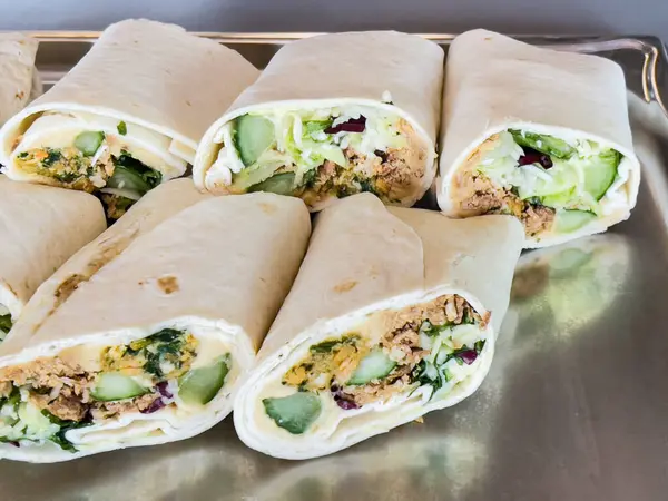 Marul ve diğer sebzelerle sarılmış bir tepsi. Sargılar üst üste yığılmış.