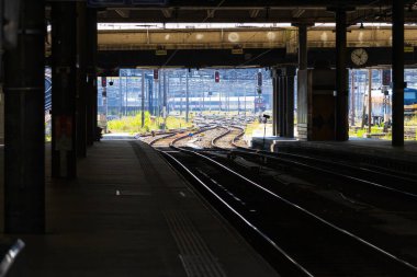 Arkasında tren ve ulaşım aracı olan bir tren istasyonu.