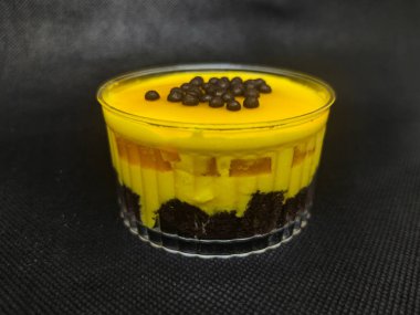 Tatlı mango tatlısı browni ve kremayla kaplı, üstüne çikolata topları eklenmiş..