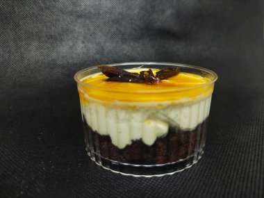 Tatlı tatlı fincanı, browni katmanı, vanilyalı krema ve meyveli sos, üstüne dilimlenmiş hurma eklendi..