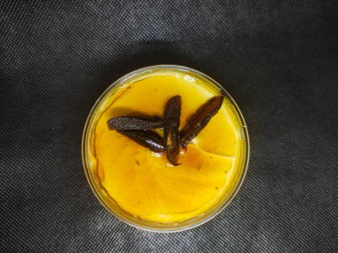 Meyve soslu ve dilimlenmiş hurma soslu tatlı fincanın en üst görüntüsü..
