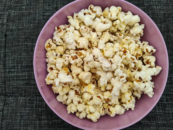 Gezouten Popcorn Een Paarse Kom Grijze Bank — Stockfoto