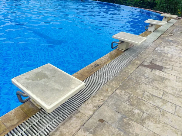 Swimming starting block in the poolside. Starting position to jump in to the pool