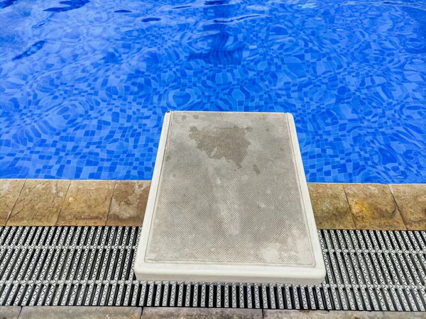 Swimming starting block in the poolside. Starting position to jump in to the pool