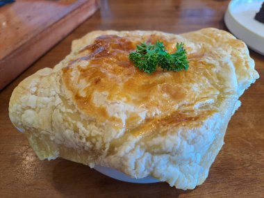 Zuppa soup, a thick and creamy soup places in cup with puff pastry covering on the top like a hat, contains corn, carrot and chicken meat