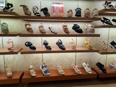 Various product of ladies sandals arranged on shelf in the shoe store