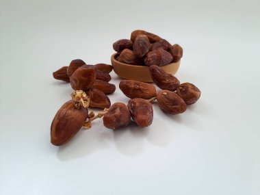 Tunisian dates fruit isolated on white background. The Deglet Nour, sweet dried palm fruit popular in ramadhan for breakfasting or takjil. Selective focus